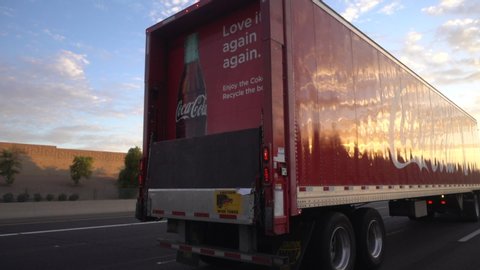 Phoenix,Az/USA 8.11.19  The Coca-Cola Company is an American beverage corp known for Coca-Cola, invented in 1886 by a pharmacist. Footage of truck driving on highway pan across trailer red white logo.