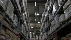 Slow Motion Logistics Industry Warehouse Aisle Travel Shot. Walking through a huge warehouse corridor with shelves full of boxes, dolly shot - Powered by Shutterstock - Get 15% off with code: PIKWIZARD15