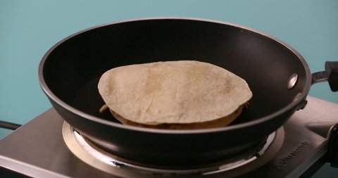Putting a tortilla in a skillet adding shredded cheese, a slice of cheese, chicken on a second tortilla to prepare a quesadilla and serving it