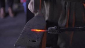 Slow Motion: Video Of A White Blacksmith Hammering A Red Hot Metal Rod