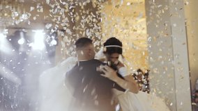 Beautiful brunette bride and handsome groom dancing first dance at the wedding party. Confetti in the air. Very tender moment - Powered by Shutterstock - Get 15% off with code: PIKWIZARD15