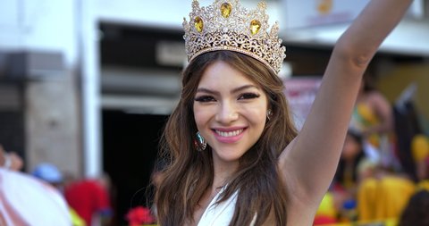 Winner of a beauty pageant contest Miss Grand Ecuador with crown smiling and waving flag in Los Angeles, California, 4K