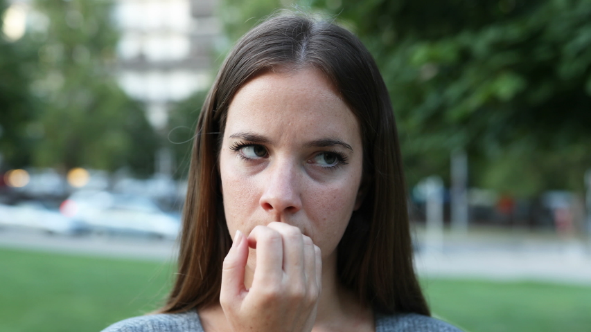 Nervous woman waiting for somebody in the street biting nails Royalty-Free Stock Footage #1035025754