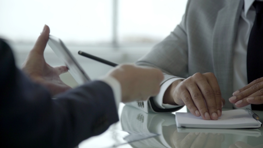 Closeup shot of two people using tablet. Cropped shot of business people sitting at table and using tablet. Business and technology concept Royalty-Free Stock Footage #1035032243