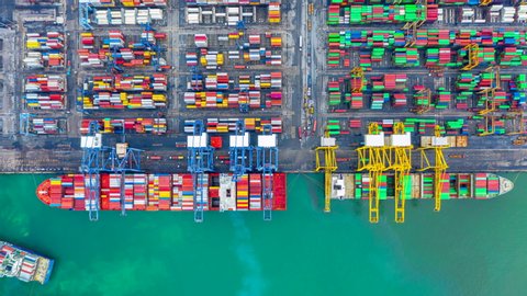 Aerial view time lapse container ship carrying container in import export business logistic and transportation of international by container cargo freight ship, Container ship at industrial port, 4K