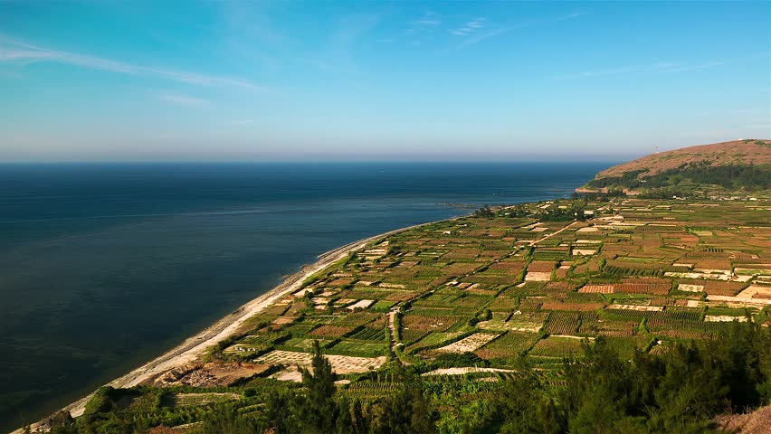 Sunny day island view with sea and fields. Time lapse panning