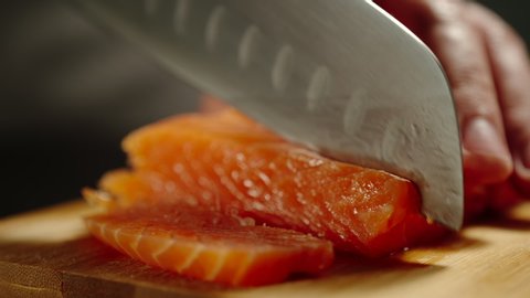 Man Cutting Red Fish On Wooden Board