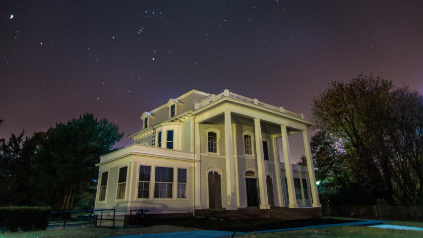 Timelapse of stars over house.
