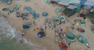 Top view, aerial view fishing harbour from drone. Royalty high-quality free stock footage of basket boat at Mui Ne fishing harbor or fishing village. Fishing harbor is a popular tourist destination