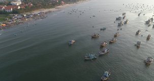 Top view, aerial view fishing harbor market from a drone. Royalty high-quality free stock video footage of market at Mui Ne fishing harbour or fishing village. Fishing harbor is a popular tourist dest