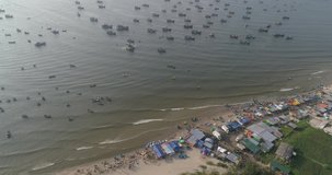 Top view, aerial view fishing harbor market from a drone. Royalty high-quality free stock video footage of market at Mui Ne fishing harbour or fishing village. 