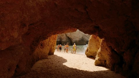 ALVOR, circa 2019 - Walking through the stunning caves and rock formations of the Tres Irmaos beach in Alvor, The Algarve, Portugal
