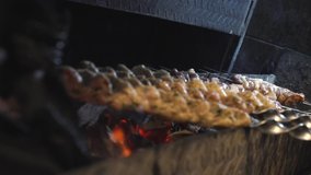 Someone's frying a kebab. The chef is preparing a meat kebab. Shish kebab is being prepared at the stake. Meat is fried. Food video close up slow motion restaurant kitchen. 