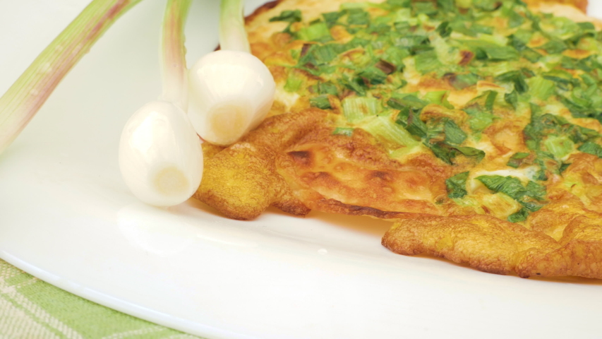 Onion pizza on white dish. National cuisine of Udmurts: The Tabani. Onion Feathers and Tortilla