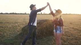 teamwork happy family smart farming concept slow motion video . girl and man agronomist shake hands business agreement teamwork in field with haystacks grass is studying and examining crops before