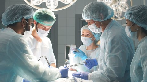 Multiracial Team of Surgeons concentrating on a patient during a heart surgery at a hospital.