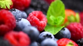 Berries. Various colorful berries rotation background. Mint leaves, Strawberry, Raspberry, Blackberry, Blueberry close-up rotating backdrop. Fresh Bio Fruits, Healthy eating, diet. 4K UHD video