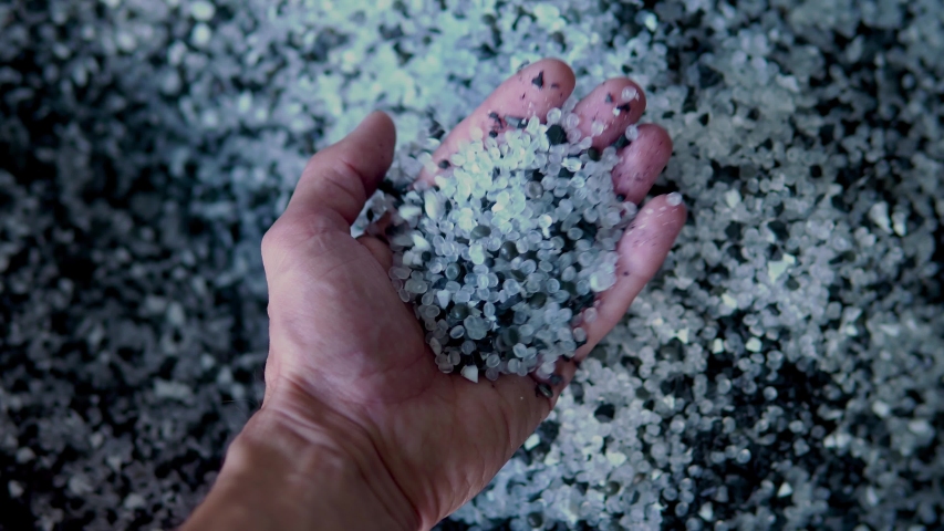 Plastic black and white granules are poured from the hand. Plastic granules, dye, polymer granules are used for the production of plastic products | Shutterstock HD Video #1035100295