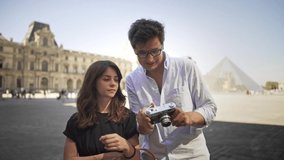 Handsome man and pretty woman are tacking pictures of Paris. Travel concept