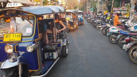 Chiang Mai, Thailand - August 10, 2019: Rickshaw Tuk Tuk in Chiang Mai streets. Local taxi drive in busy Asian street.