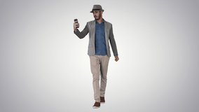 Attractive man in casual clothes hat hipster stylerecording vlog or making a video call on gradient background.