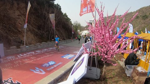 Beijing / China - 05 09 2019: Spectators cheer on elated runners as they cross the finish line at the Jinsanling Great Wall Marathon.