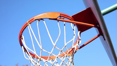 Close-up shot of a swish shot made on an outdoor basketball hoop.