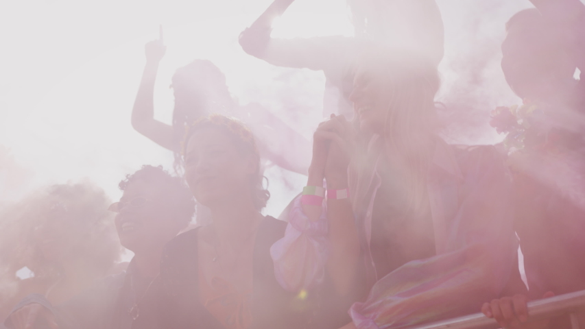 Group Of Young Friends Dancing Behind Barrier At Outdoor Music Festival