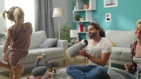 adorable little girl dancing with dad and mom at living room