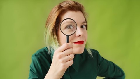 Search. A young woman with a magnifying glass searching, investigates and studies.