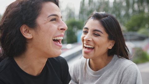 Two Female Friends Meeting In Urban Skate Park