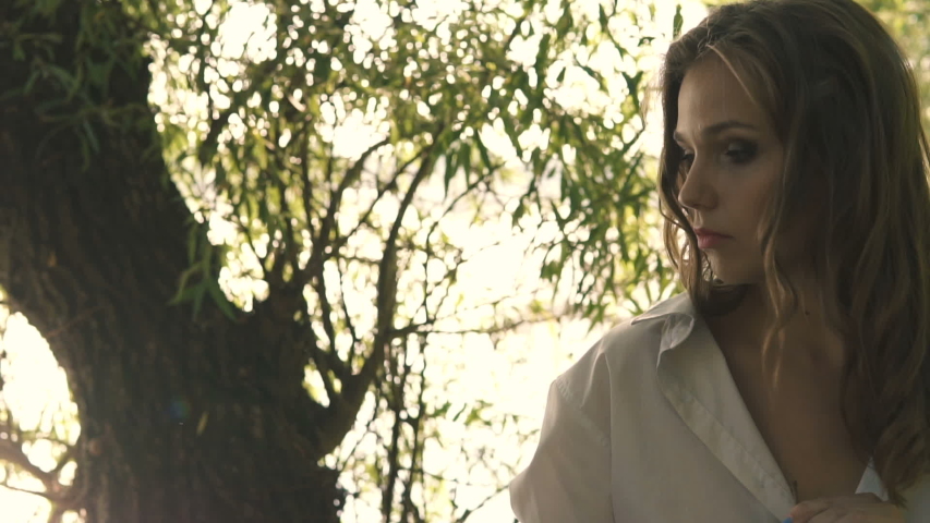 Beautiful Young Sexy Girl In A White Shirt Walks Along River Bank Among Trees
