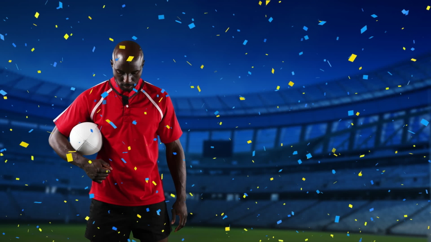 Animation of an African American male rugby player holding a ball and looking to camera with blue and yellow confetti falling and sports stadium in the background