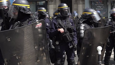 Paris / France - 05 01 2019: A riot police officer stands branching a tear gas launcher gun