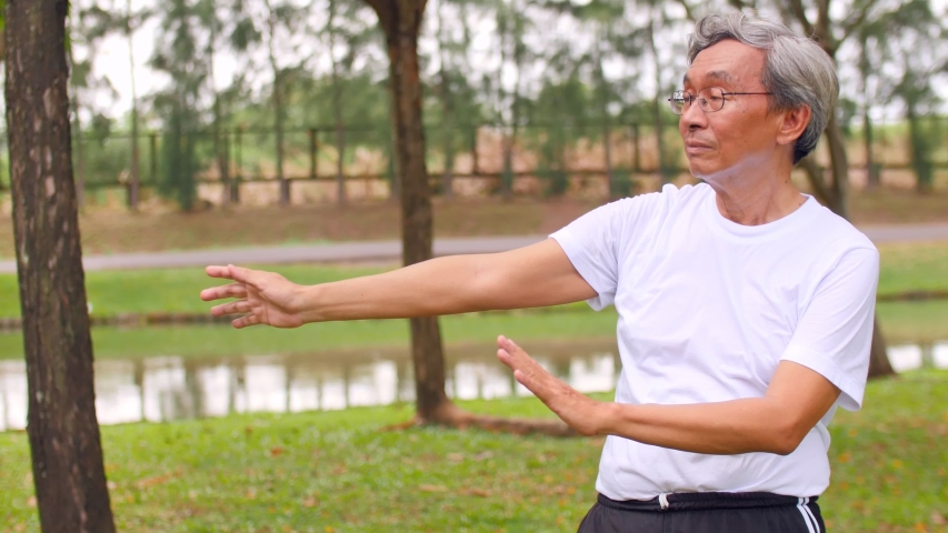Elderly man practicing Tai Chi Quan, Asian senior man exercising in the park