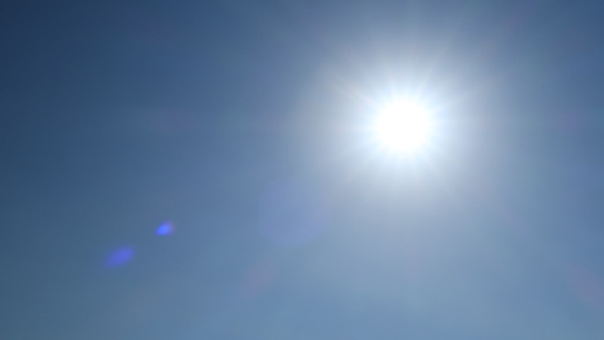 Beautiful sunny cloudless clear sky with Bright Sun Shining with sunlight ray & sunbeam, TimeLapse. Nature Bright sunrise with lens flare on tropical summer or spring sunny day, solar energy concept Royalty-Free Stock Footage #1035154607
