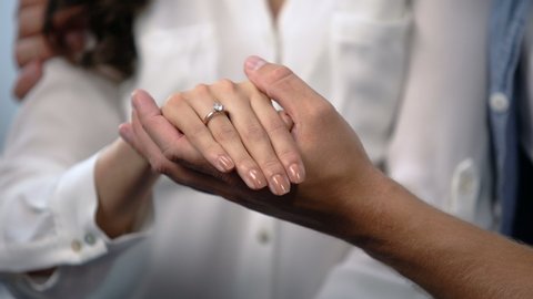 Man tenderly holding fiancee hand with engagement ring, future family, love