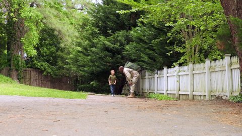 African American military father running on path with son