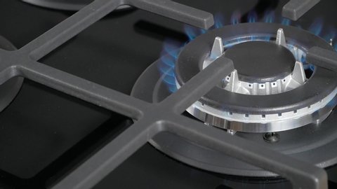 Kitchen burner turning on. close up on the flame. Natural gas inflammation in stove burner, close up view.  Gas burning from a kitchen gas stove.