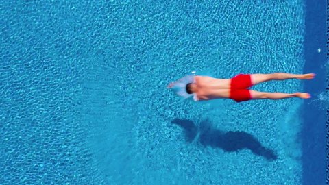 Aerial view of man in red shorts swims in the pool