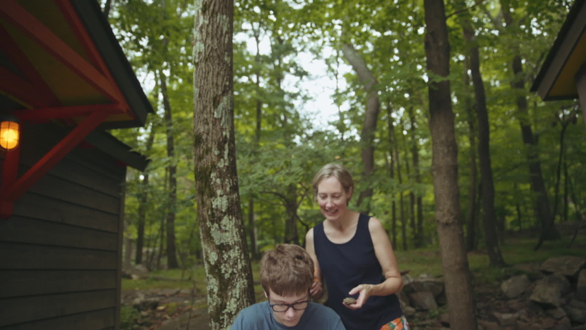 Caucasian mother and son with nature scrapbook at lake home