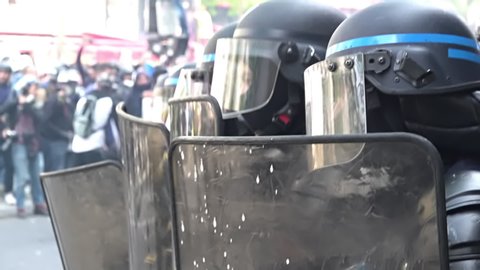 Paris / France - 05 01 2019: Slow motion of riot police unit hiding behind riot shields