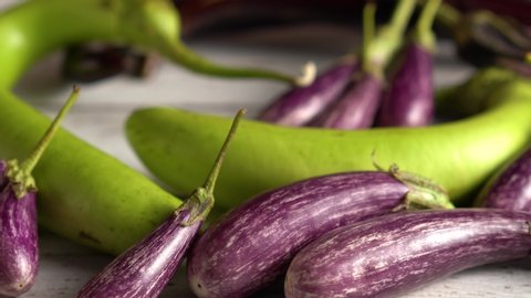 Extreme close up of fairy tale eggplants on a wood table, camera sliding to the right.