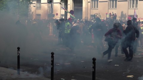 Paris / France - 05 01 2019: Slow motion of a masked man throwing a tear gas canister