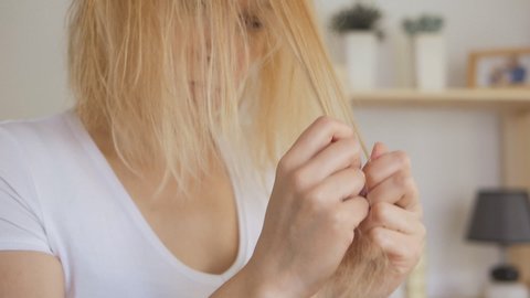 A woman combing her hair with a comb discovers a lot of fallen hair.
