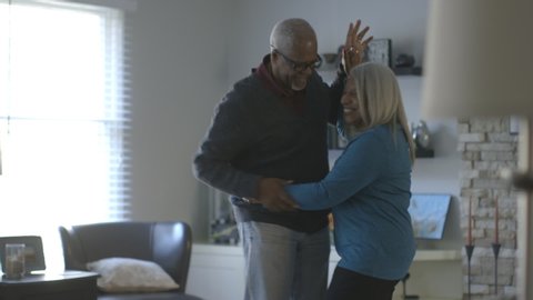 Black couple dancing in living room