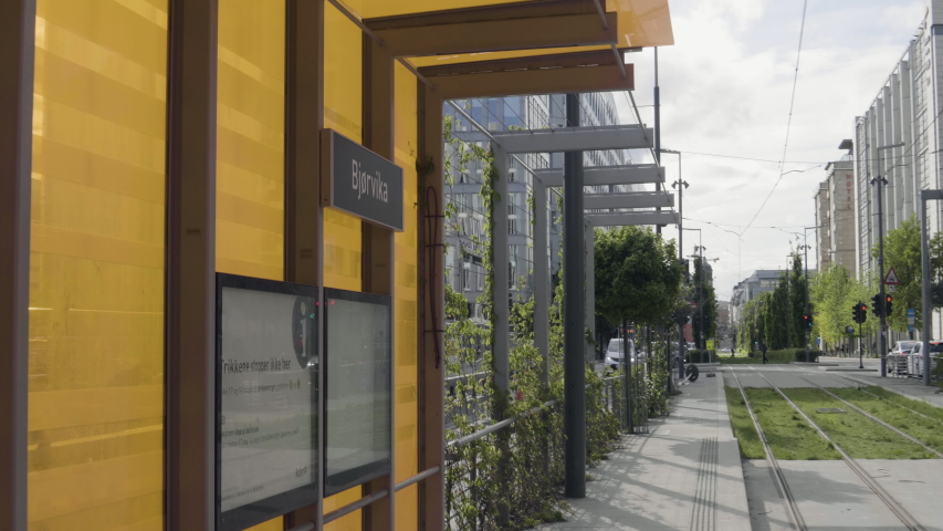 4K gimbal video with pan motion of the Bjoervika sign on a modern, orange and yellow train tram station by the Oslo Opera House and the new Barcode quarter in Oslo, Norway.