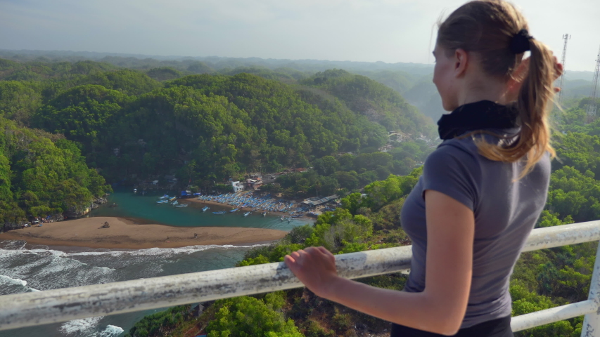 Girl admiring the landscape from Lighthouse Pantai Pandansari in Bantul region at Java island , Indonesia