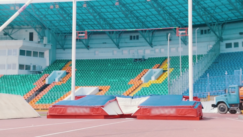 Pole vault training - an athletic man jumping over the bar in the stadium Royalty-Free Stock Footage #1035233033