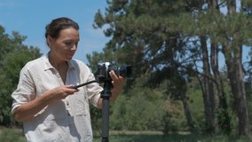 Woman photographer in nature. Woman with monopod and camera in the forest.